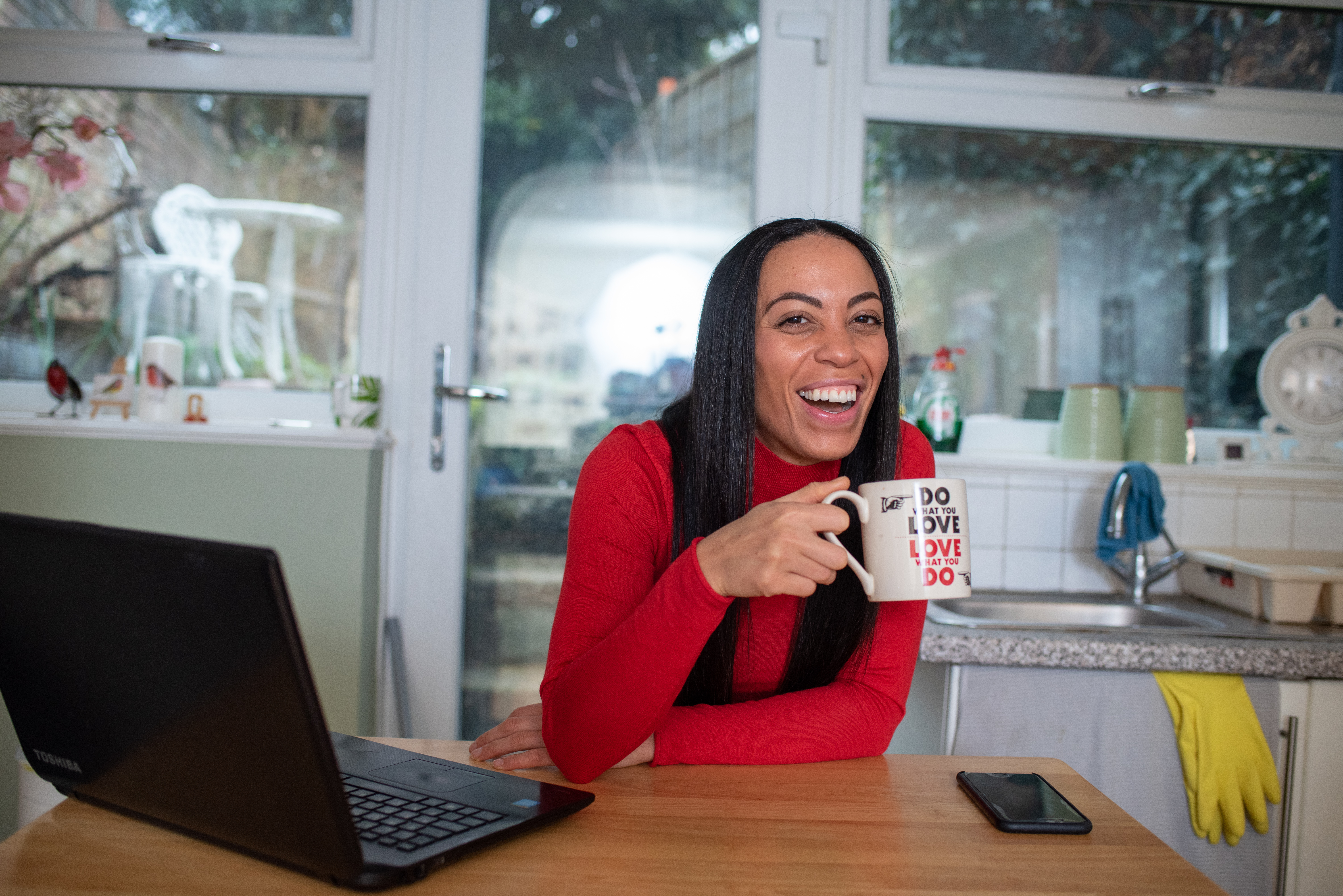 Image of a young person drinking tea next to a laptop