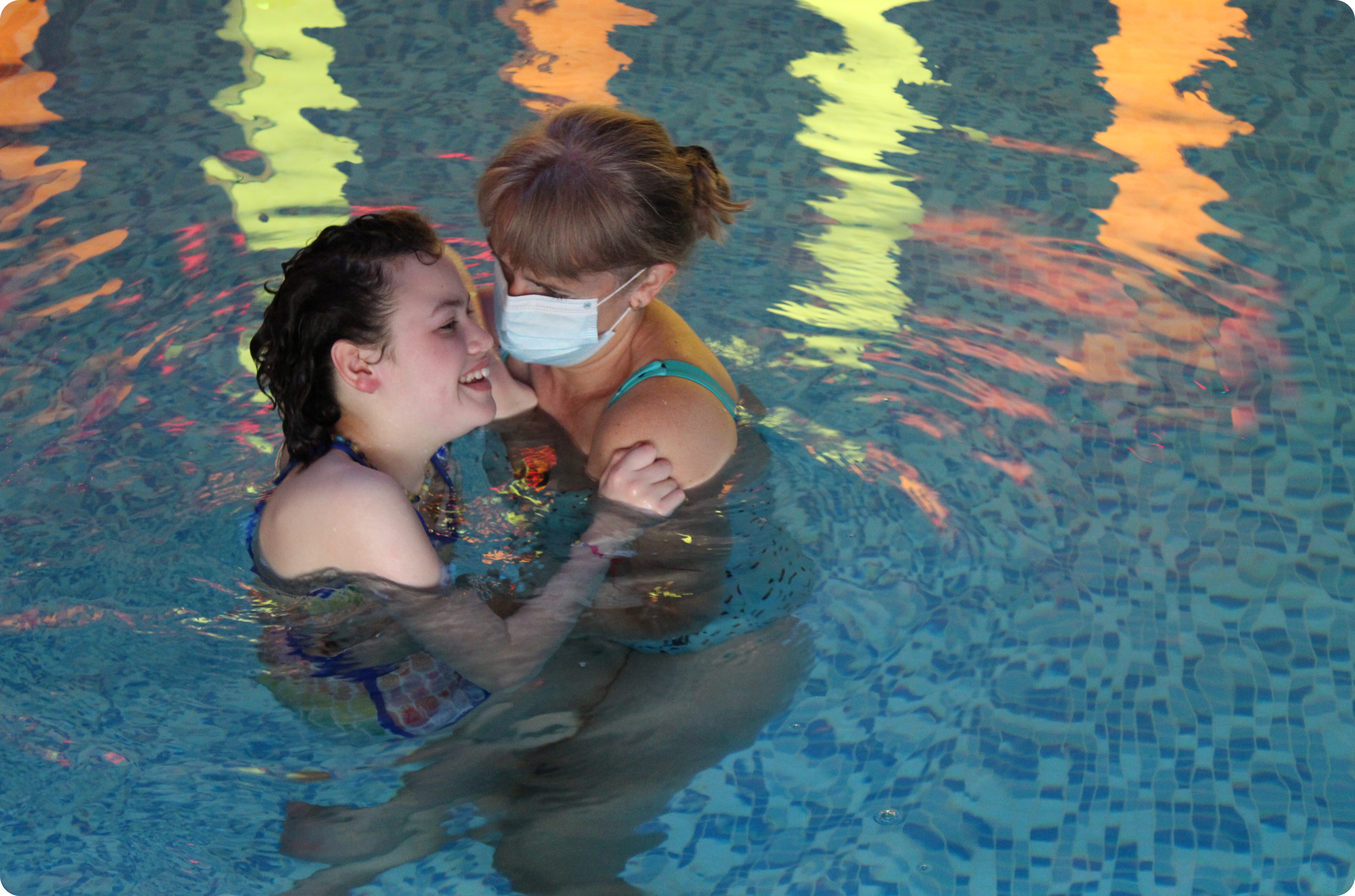 Picture of a woman holding up another young woman in the swimming pool