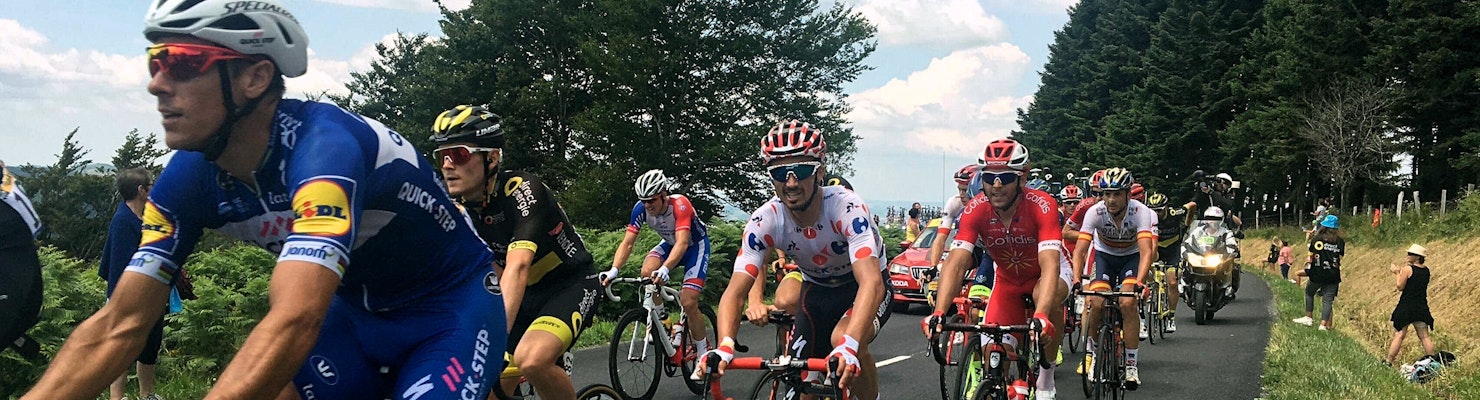 Cyclists going along a road in a large group.