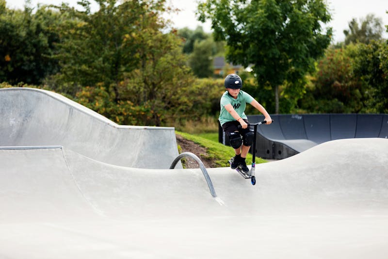 Ett barn åker kickbike i skatepark i Laholm