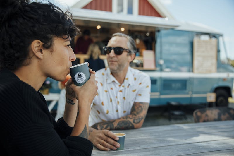 Två personer njuter av kvalitetskaffe på Swerl Coffee.
