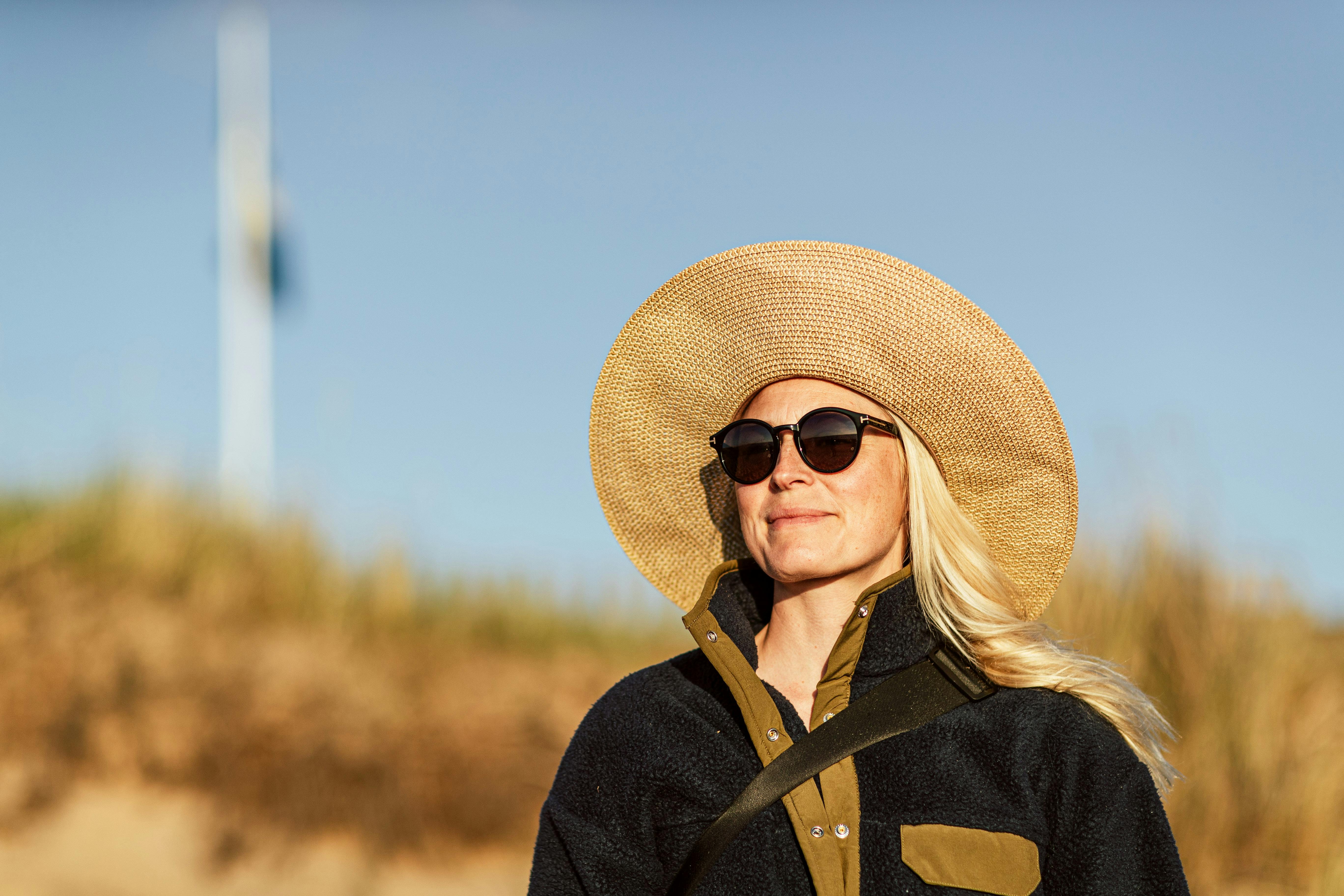 Kvinna med hatt på strand