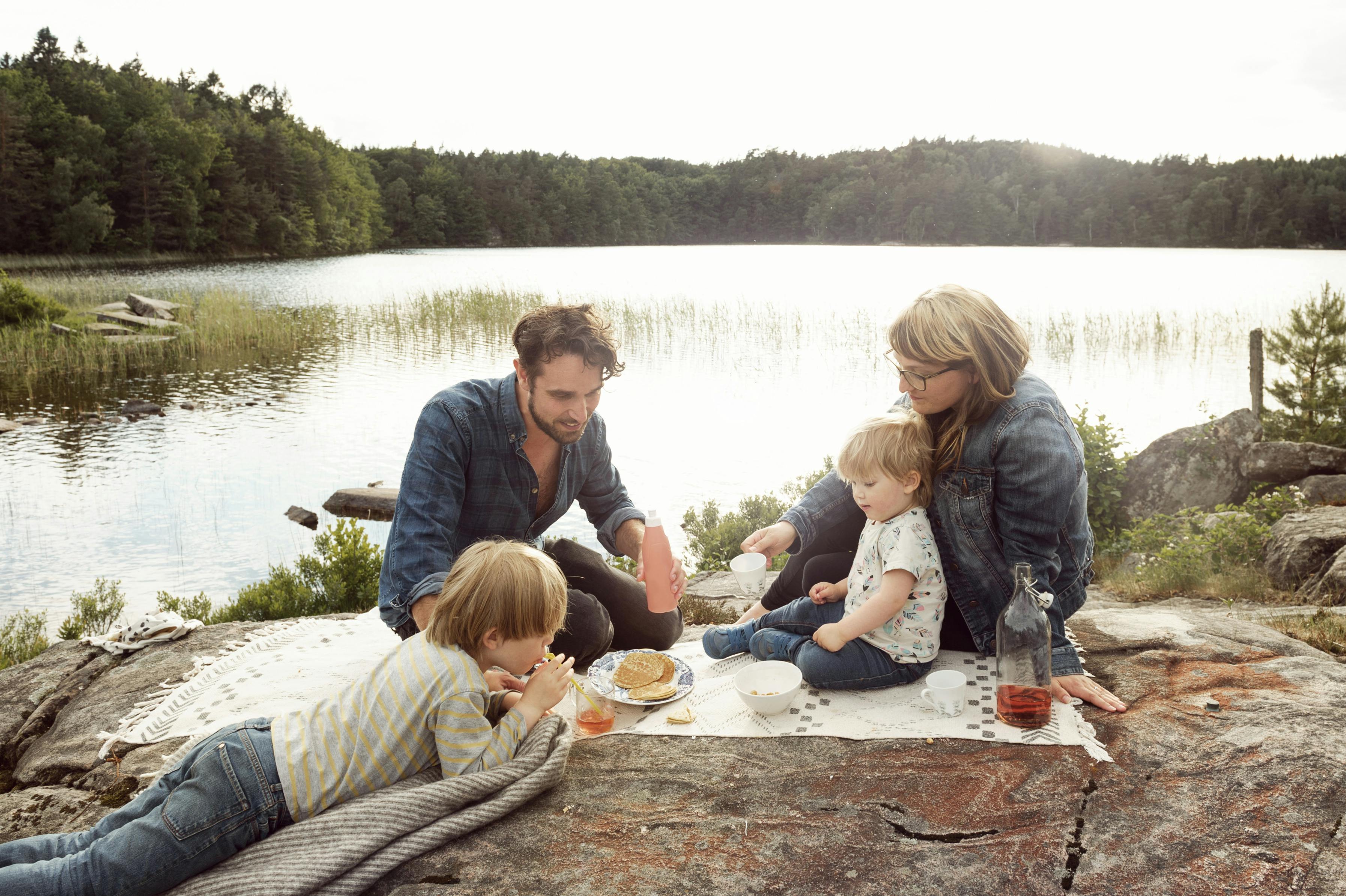 En familj har picknick nere vid sjön.