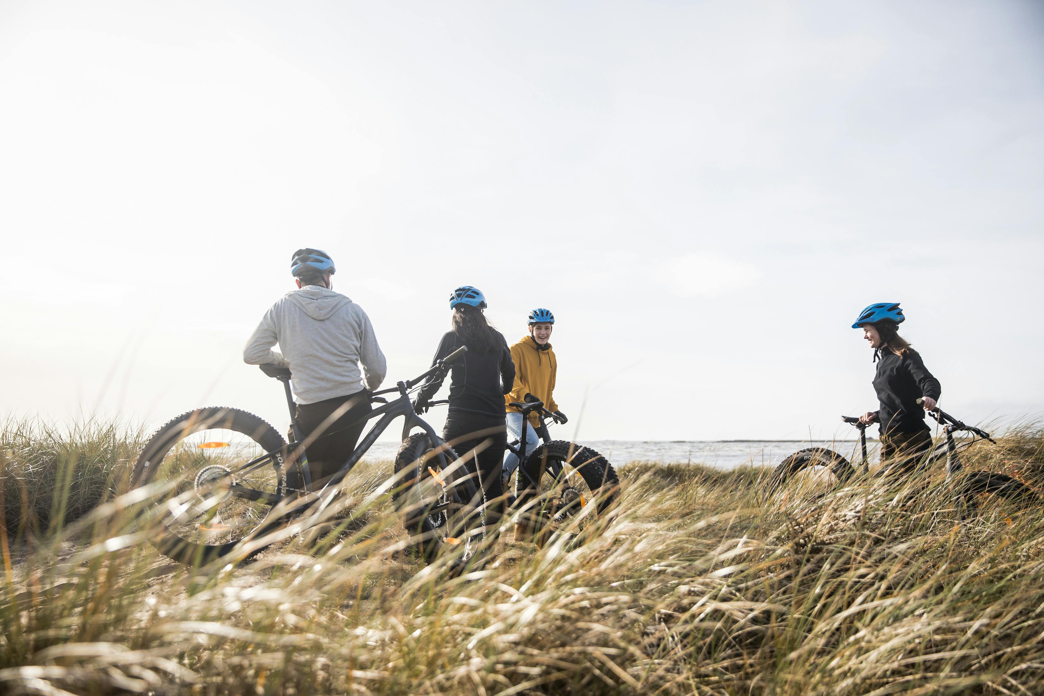 Vänner cyklar fatbike vid stranden i Vesslunda, Halland. 