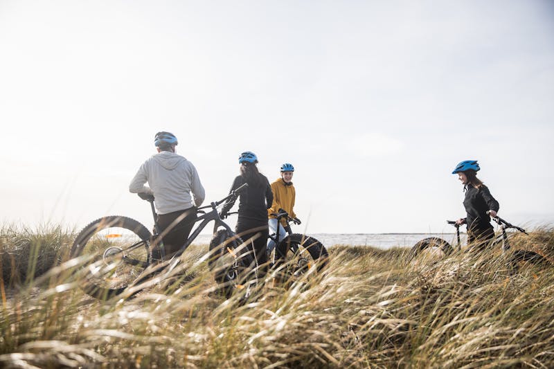 Vänner cyklar fatbike vid stranden i Vesslunda, Halland. 