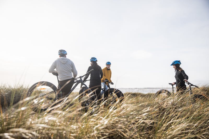 Vänner cyklar fatbike vid stranden i Vesslunda, Halland.