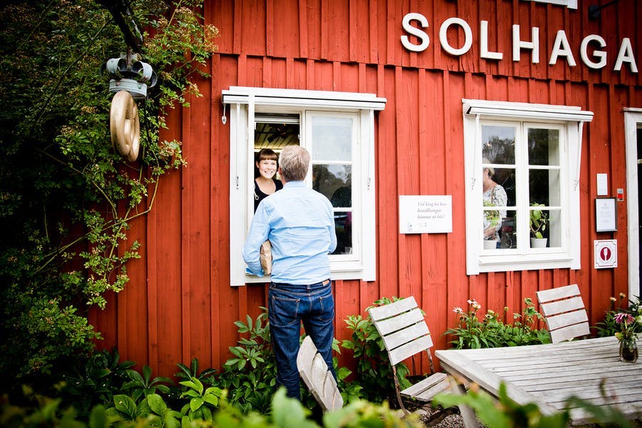 Person tar emot en påse med bullar.