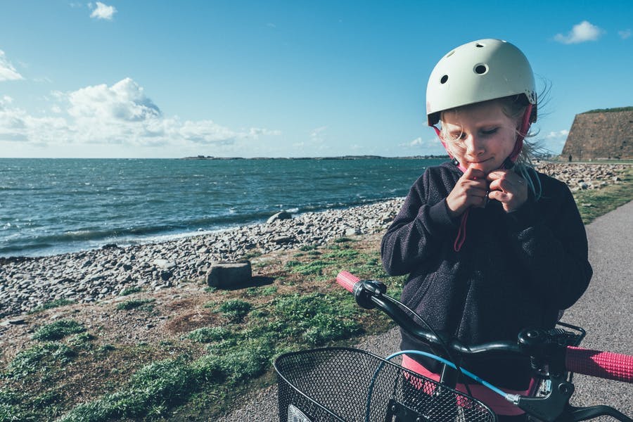 Ett barn knäpper sin hjälm.