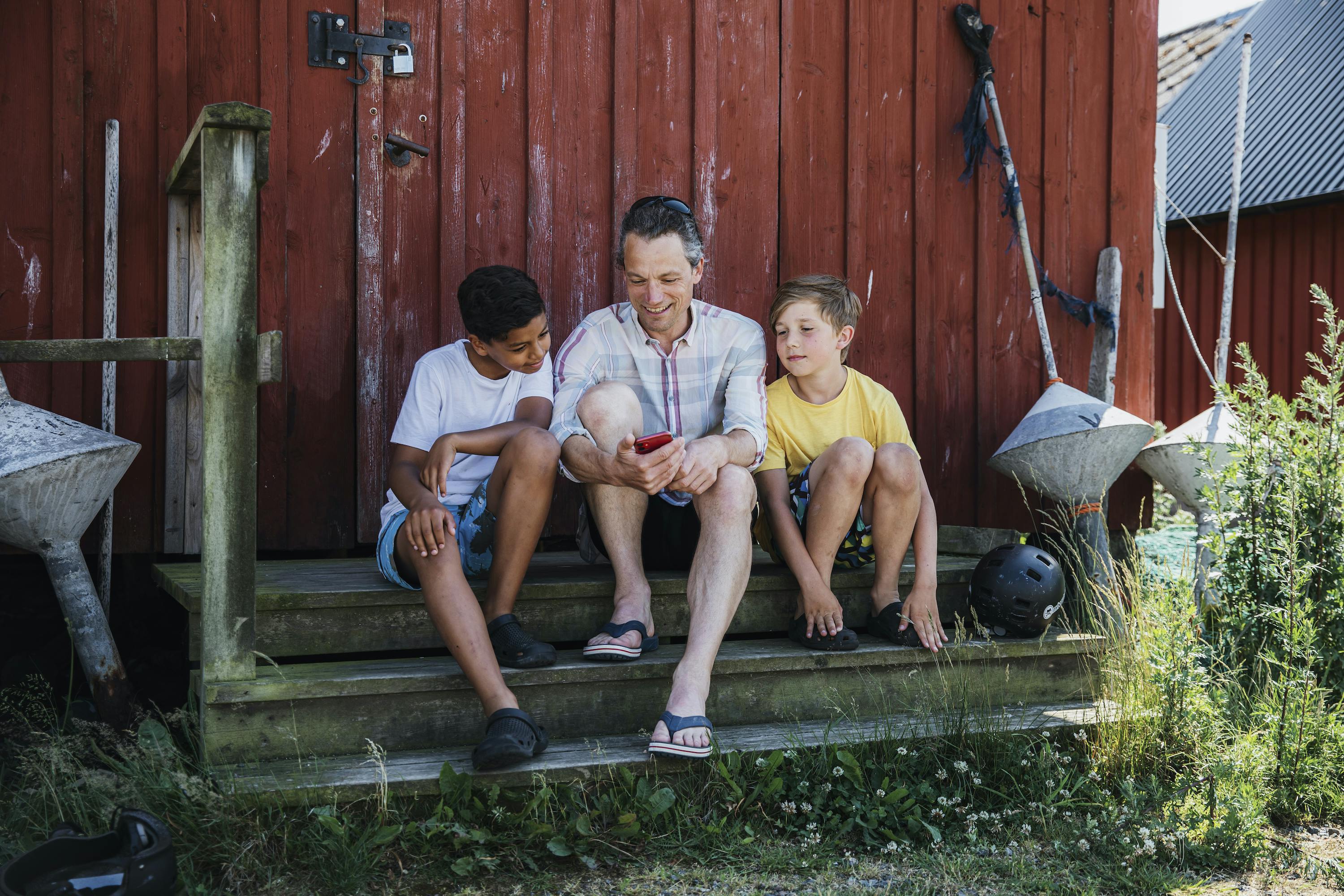 Eine Gruppe schaut sich „Ein Tag in Halland“ auf dem Mobiltelefon an.