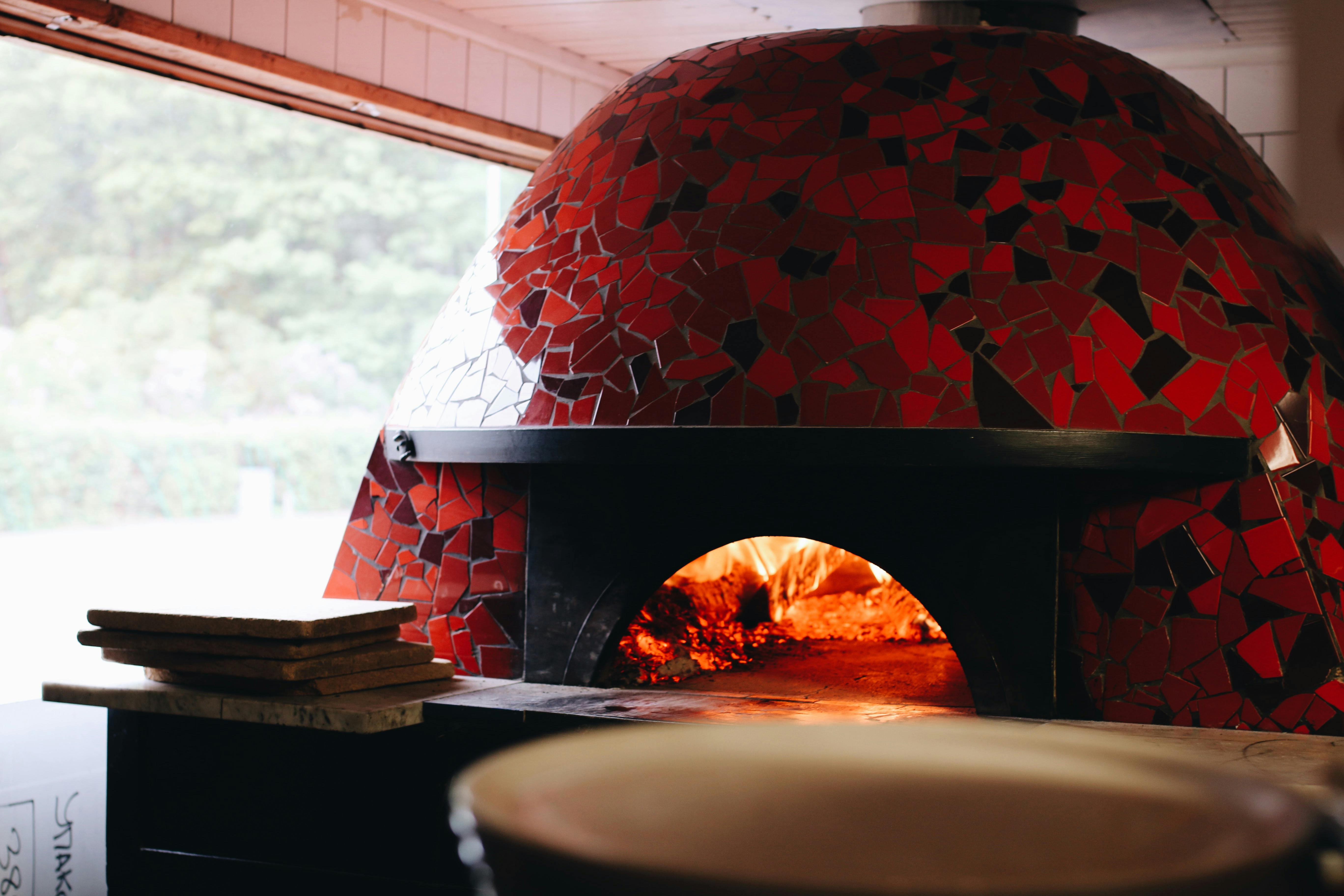 Pizzorna på Lilla Napoli gräddas snabbt i den stora pizzaugnen.
