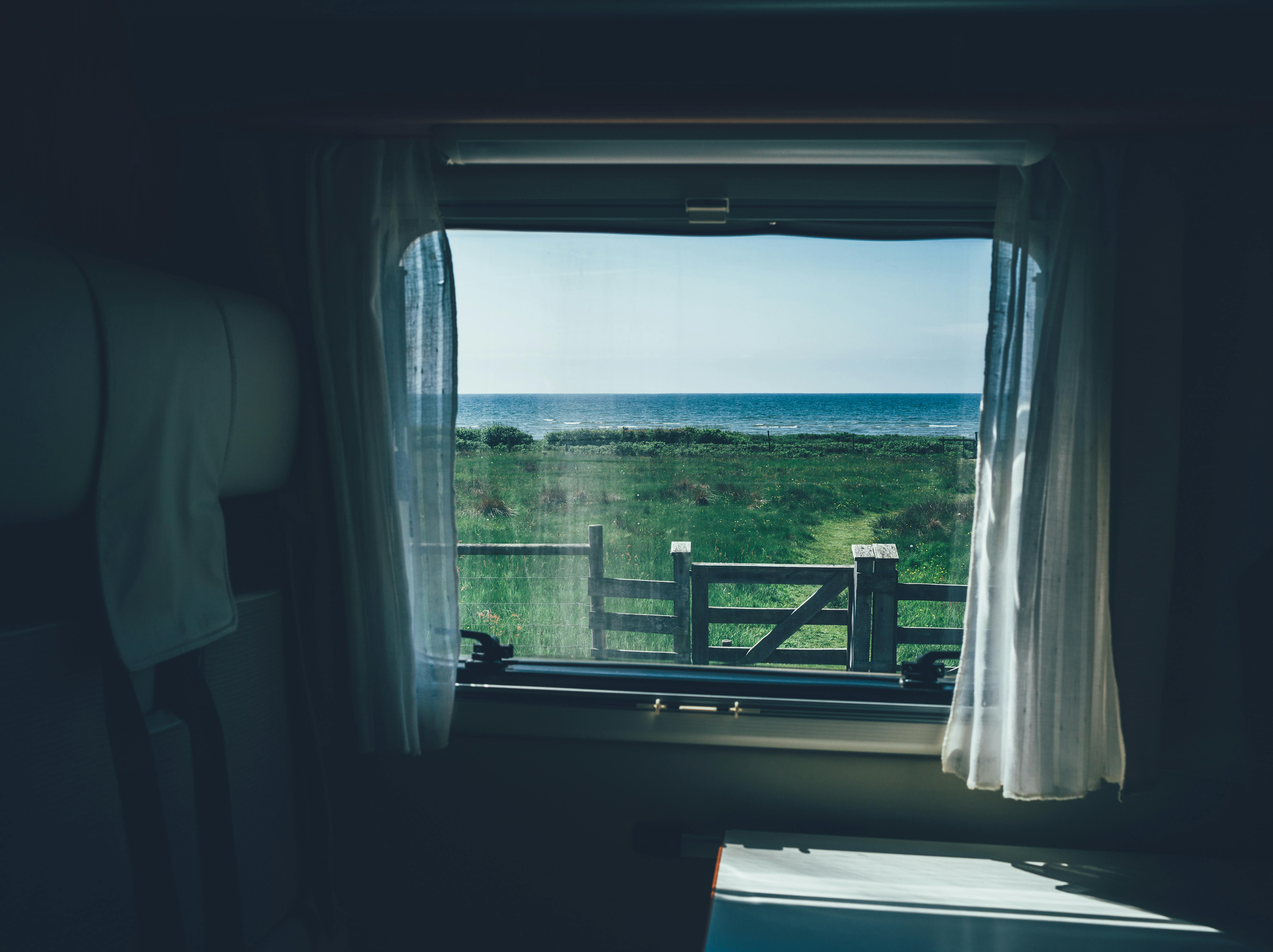Blick aus dem Fenster vom Wohnmobil aufs Meer. 