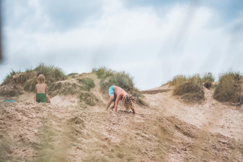 Två barn leker i sanddynen i Tylösand