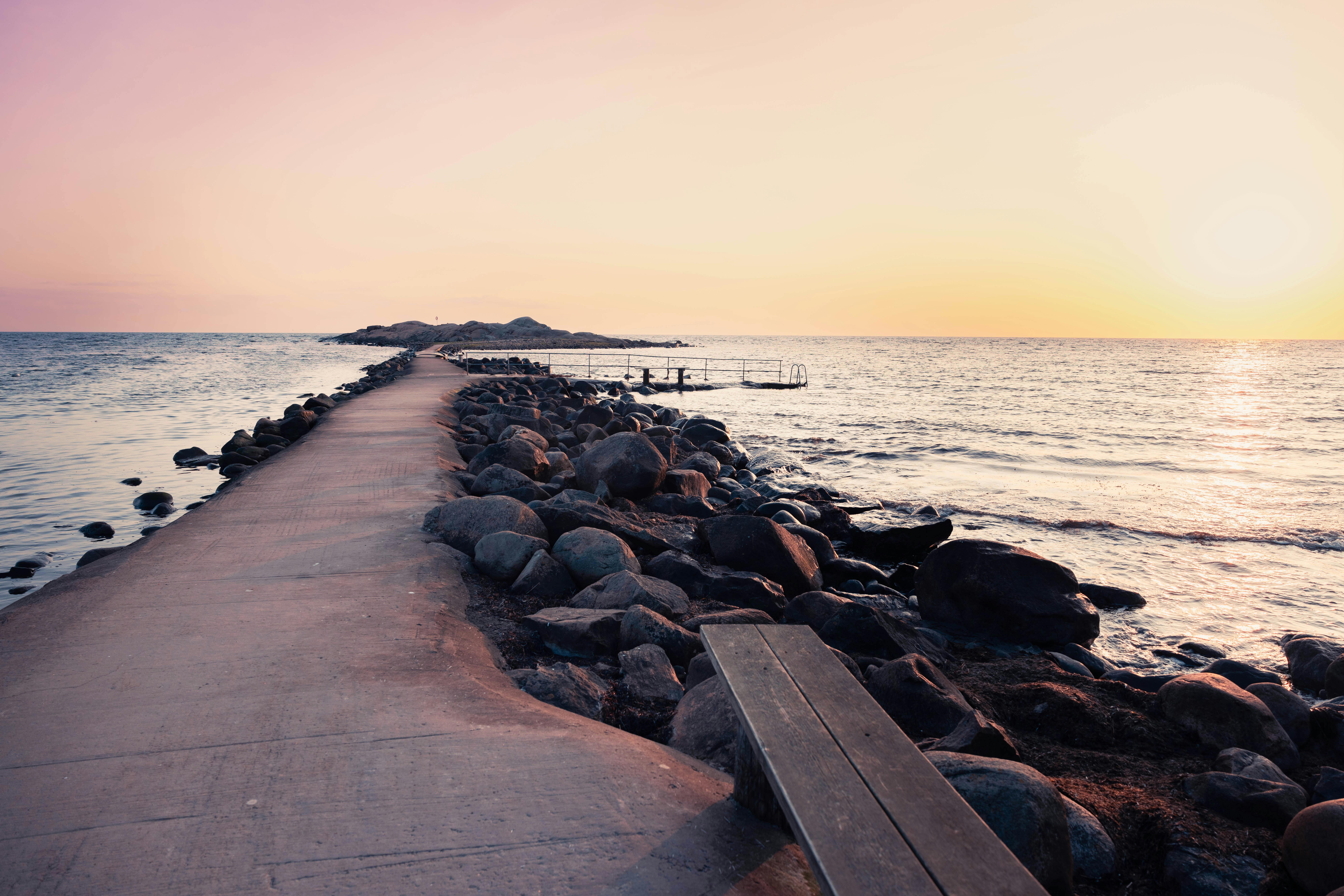 Mole mit Weg und Felsen im Sonnenuntergang