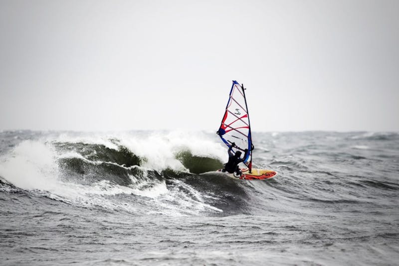 En vindsurfare surfar på vågorna.