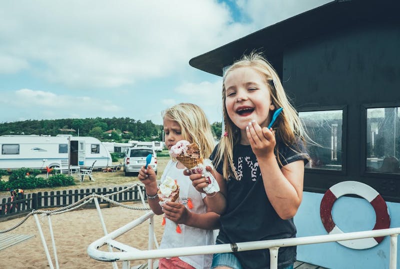 Två glada barn äter glass.
