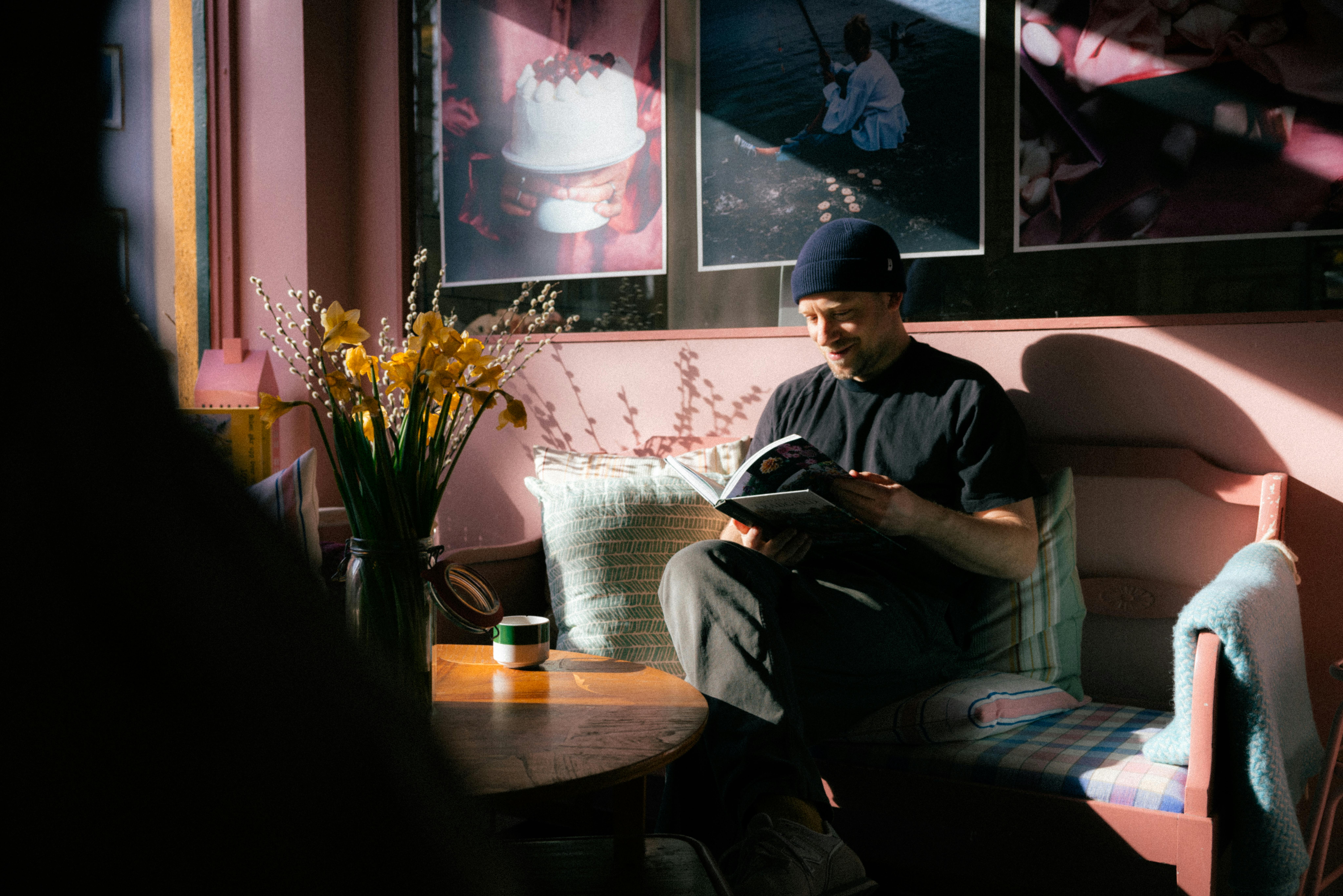 Mann liest ein Buch und macht Fika bei Feldts Bäckerei in Halmstad.