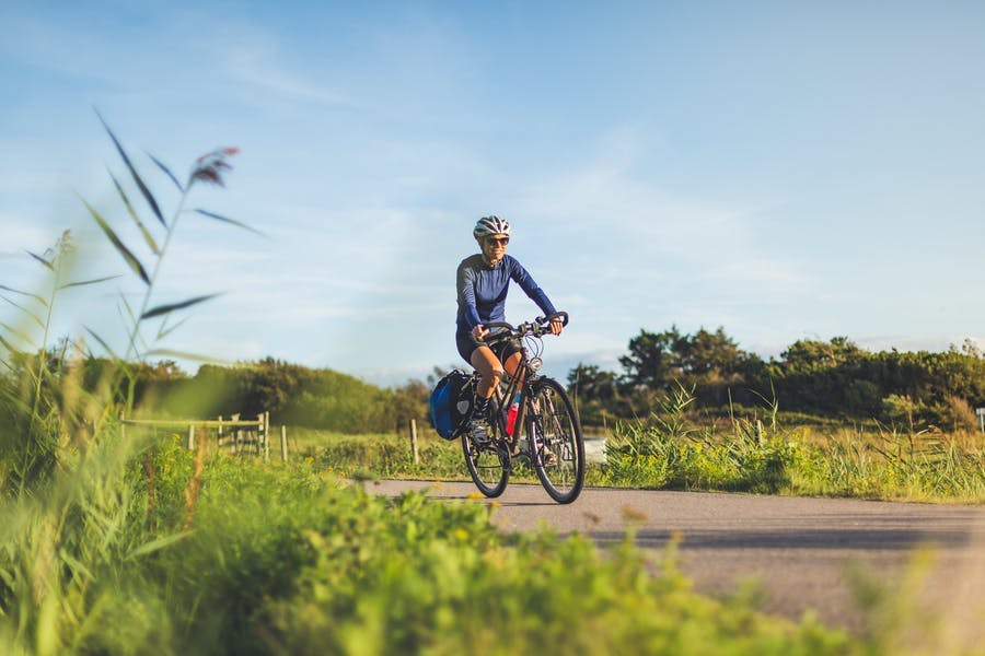 Person cyklar på Kattegattleden i solsken.