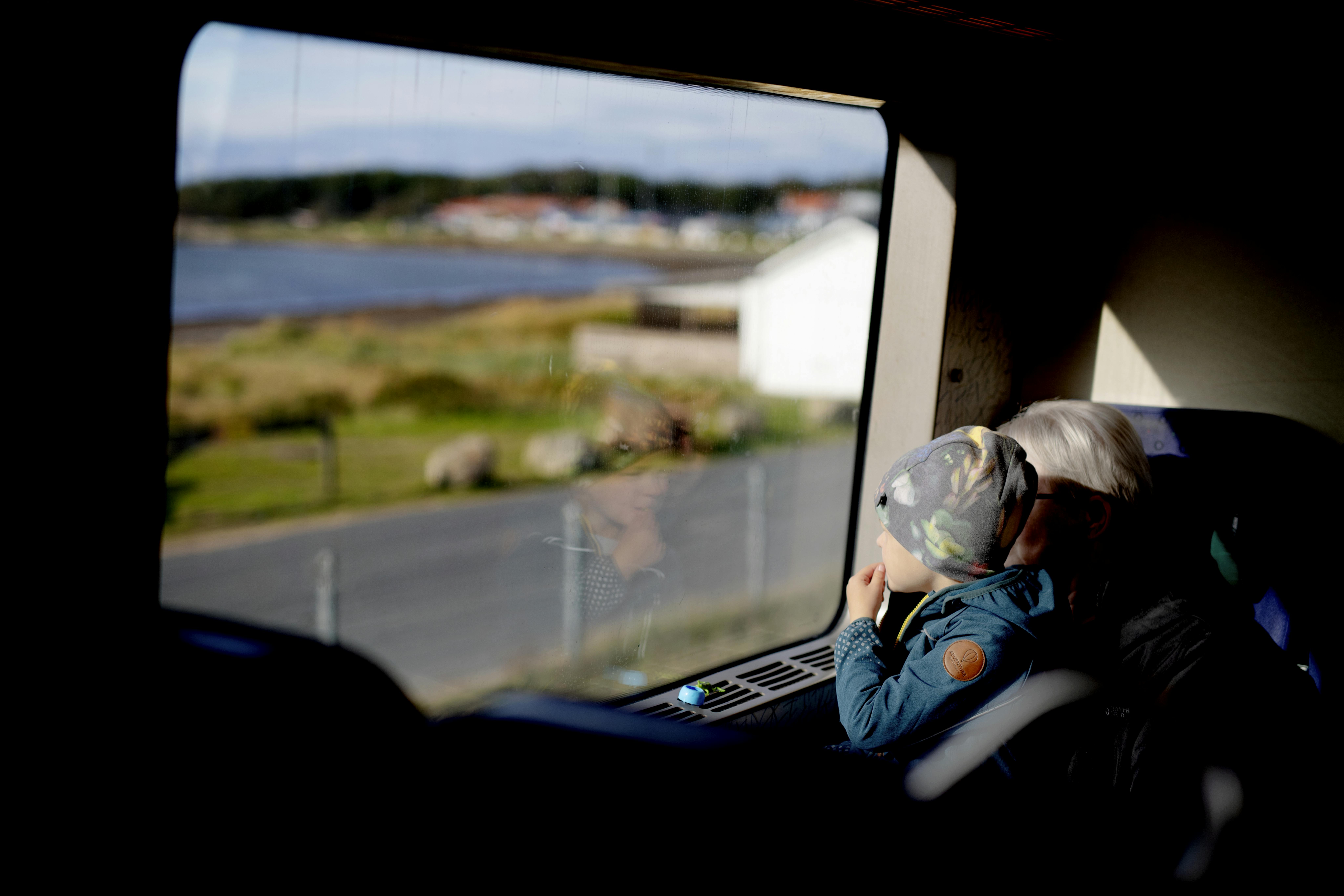 Kind schaut im Zug aus dem Fenster.