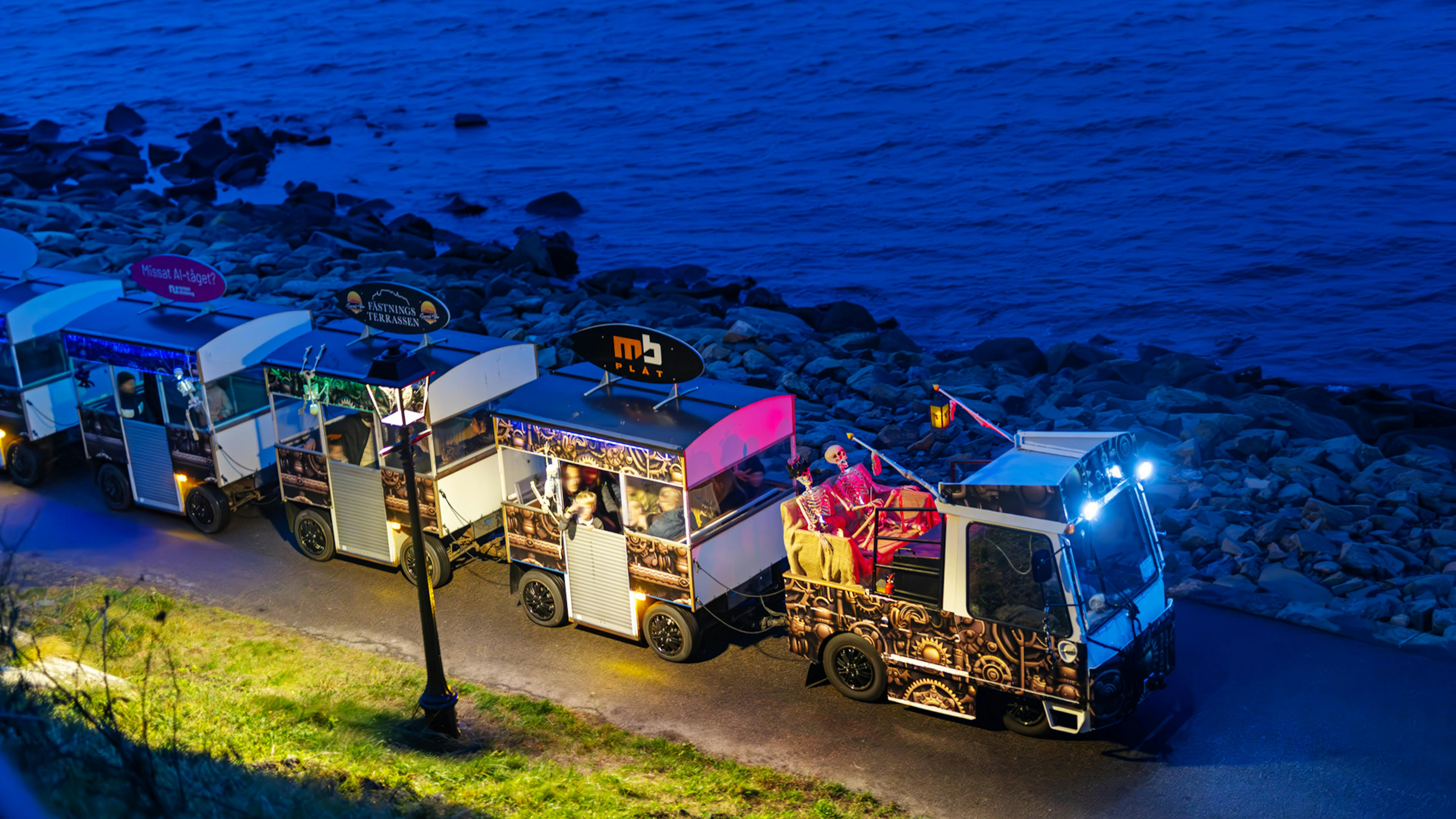Spökdekorerat litet turisttåg som kör längs strandpromenaden i Varberg.