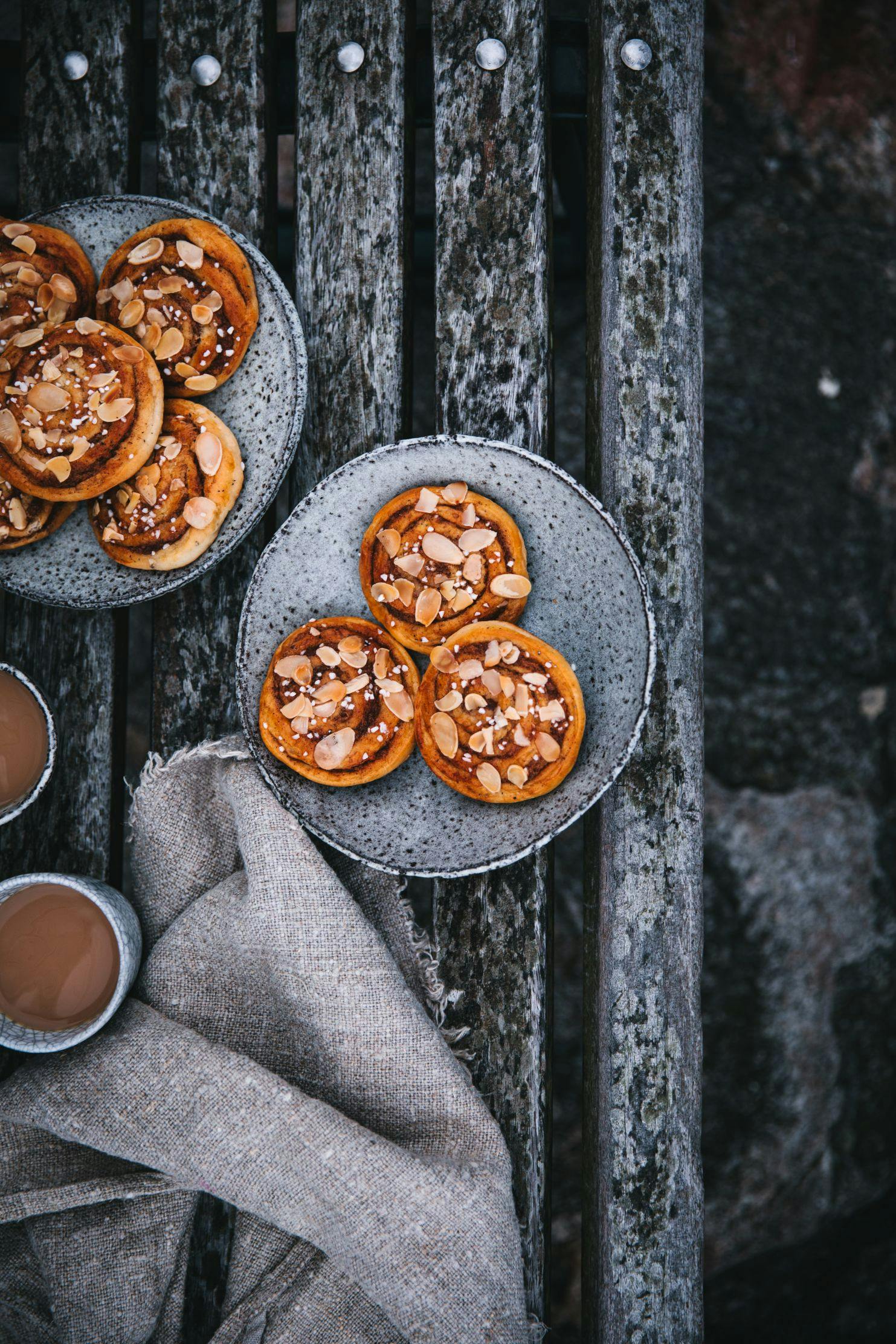 Mandelbullar och kaffe på ett ute på en frostig träbänk.