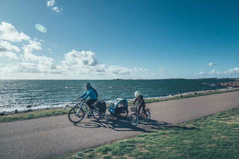 En familj cyklar längs havet på Kattegattleden.