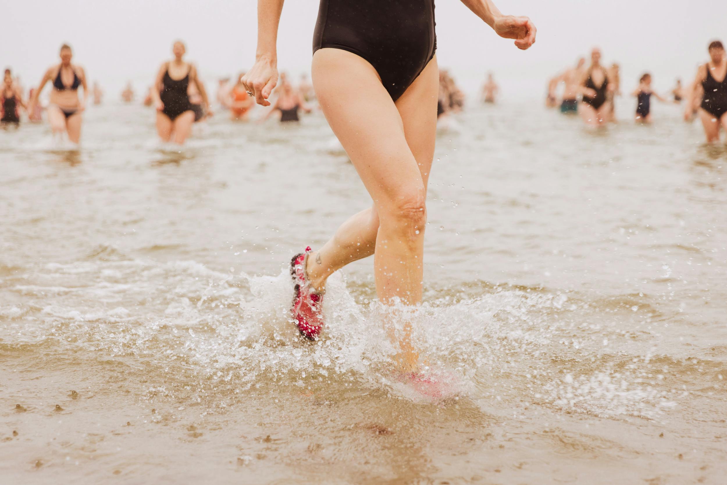 En grupp människor firar in påsken med Påskdoppet på Barnens badstrand i Varberg, Halland.