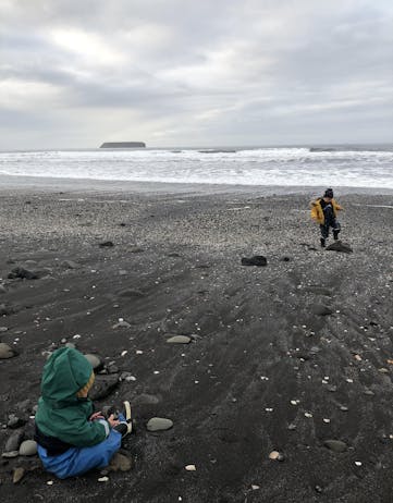 Children playing on a black beach
