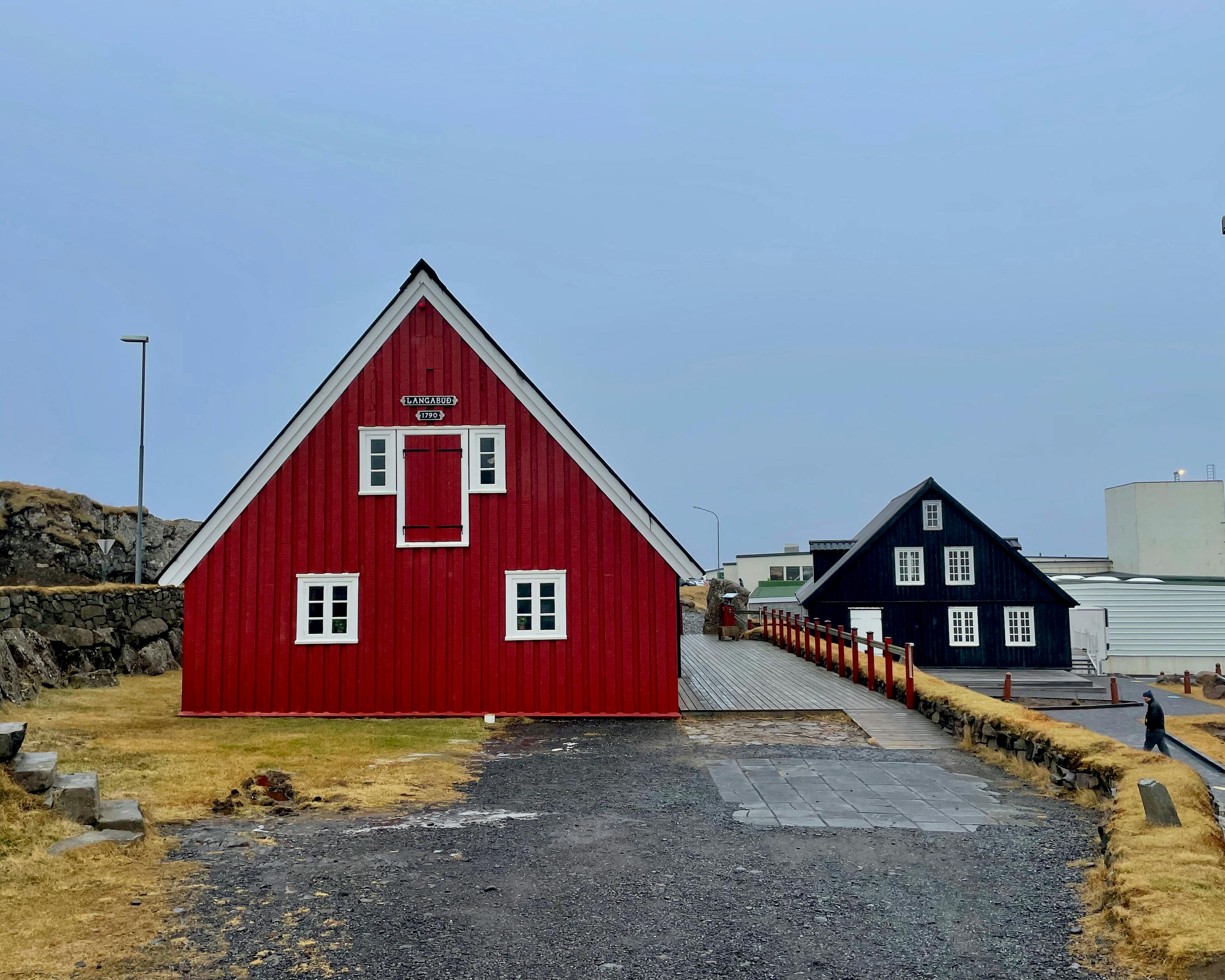Two red and black A-shaped old style wooden houses