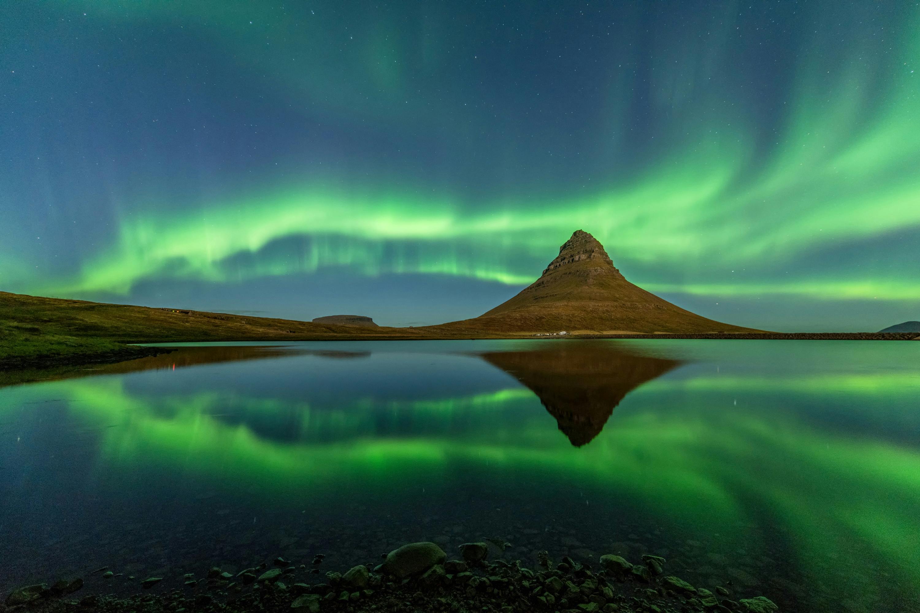 Northern lights dance above Kirkjufell mountain in Iceland