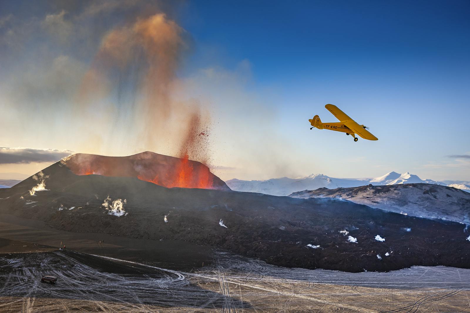 An airplane flying passed two erupting craters