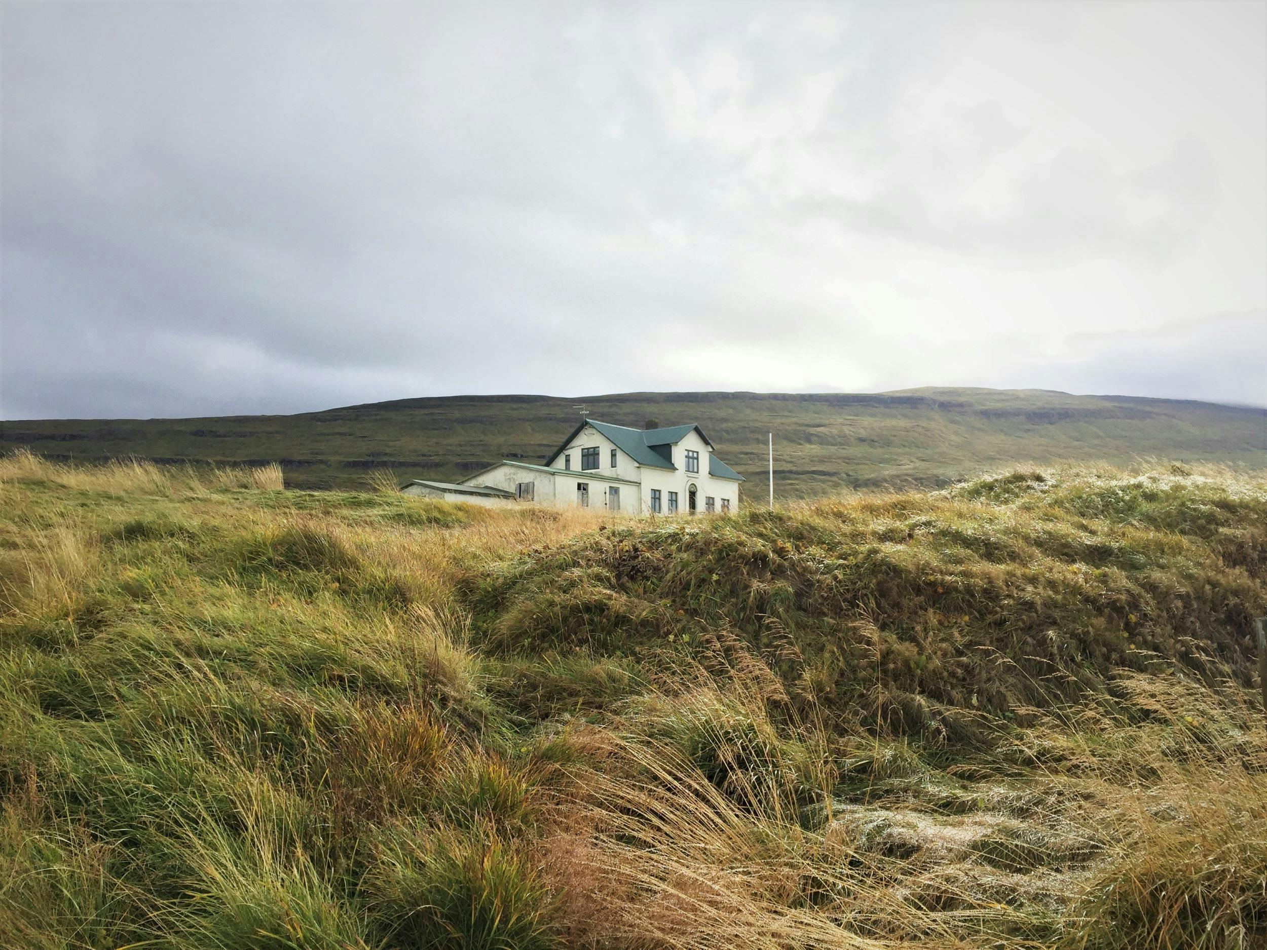 Illugastaðir farm on Vatnsnes peninsula seen from below grassy hills