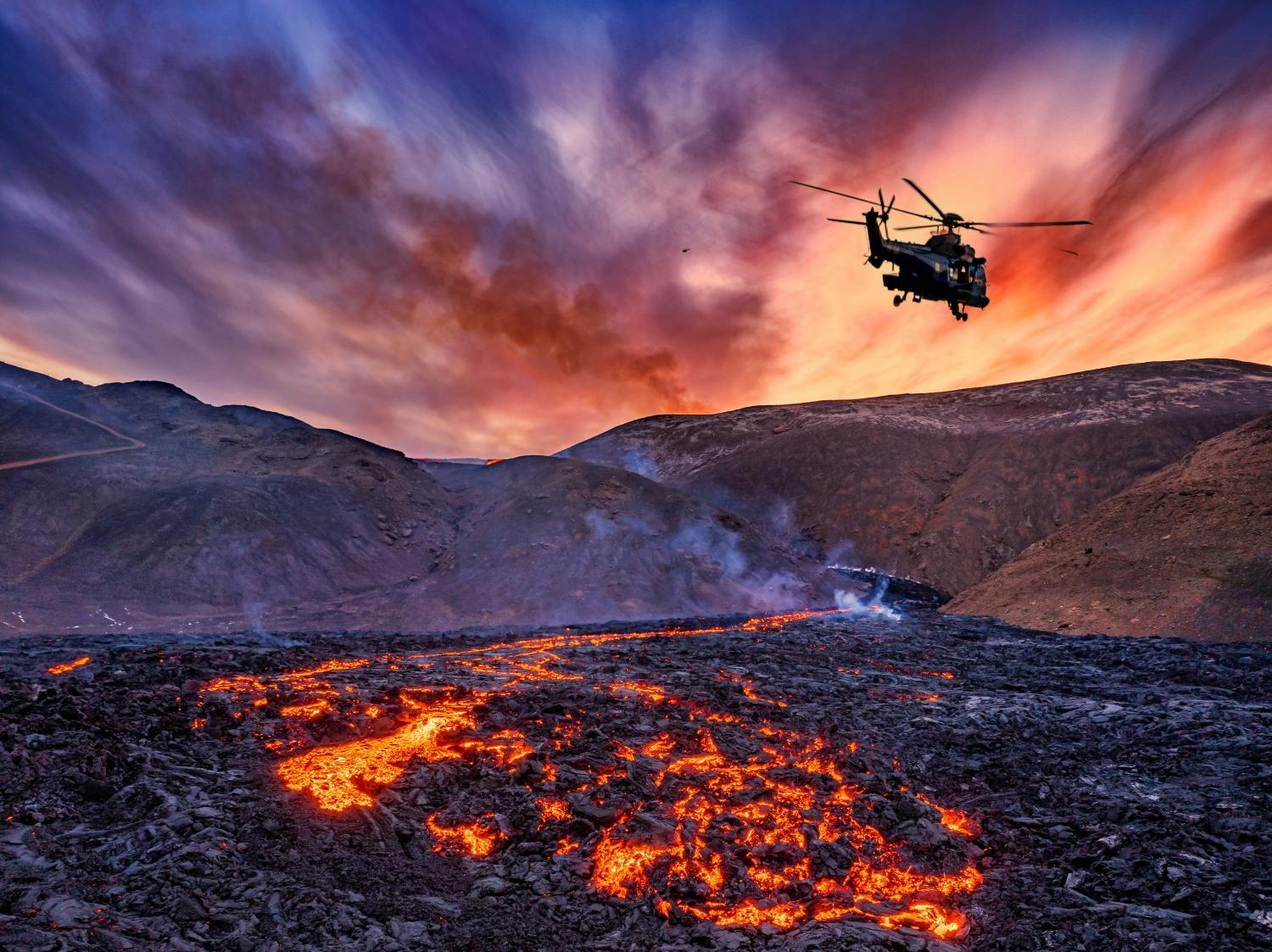 A helicopter flying over flowing lava in Iceland