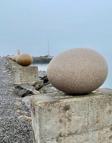 Enlarged stone replicas of eggs lined along the shoreline