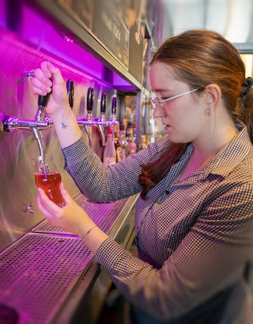 Young woman drawing a beer in an Icelandic bar