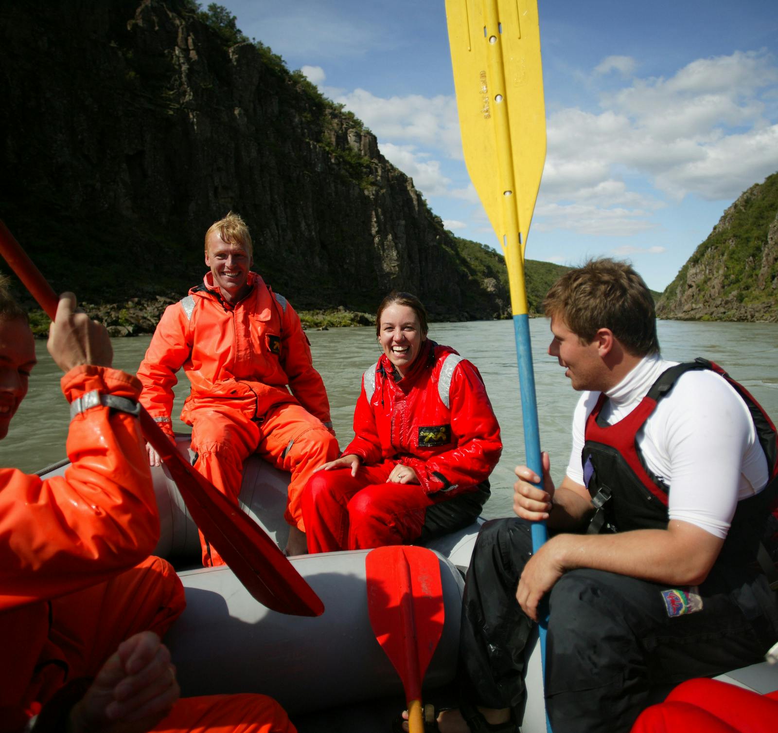 People sitting in a rafting boat , laughing