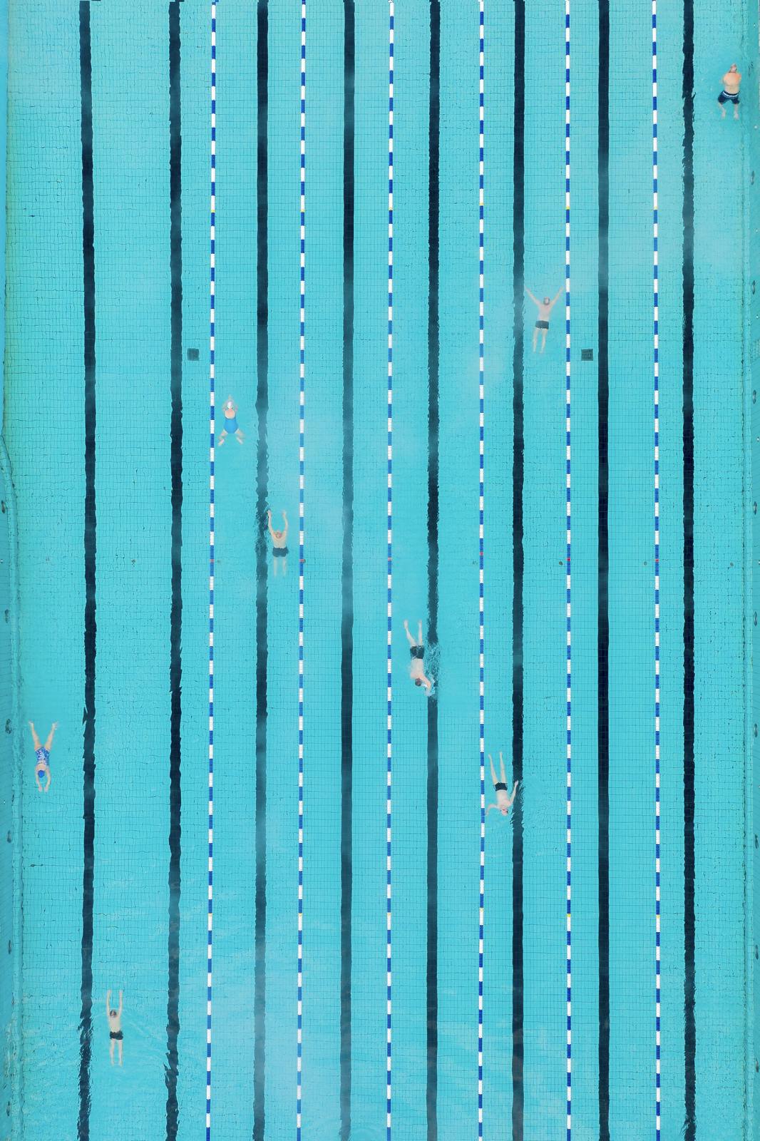 People swimming in a swimming pool as seen from above