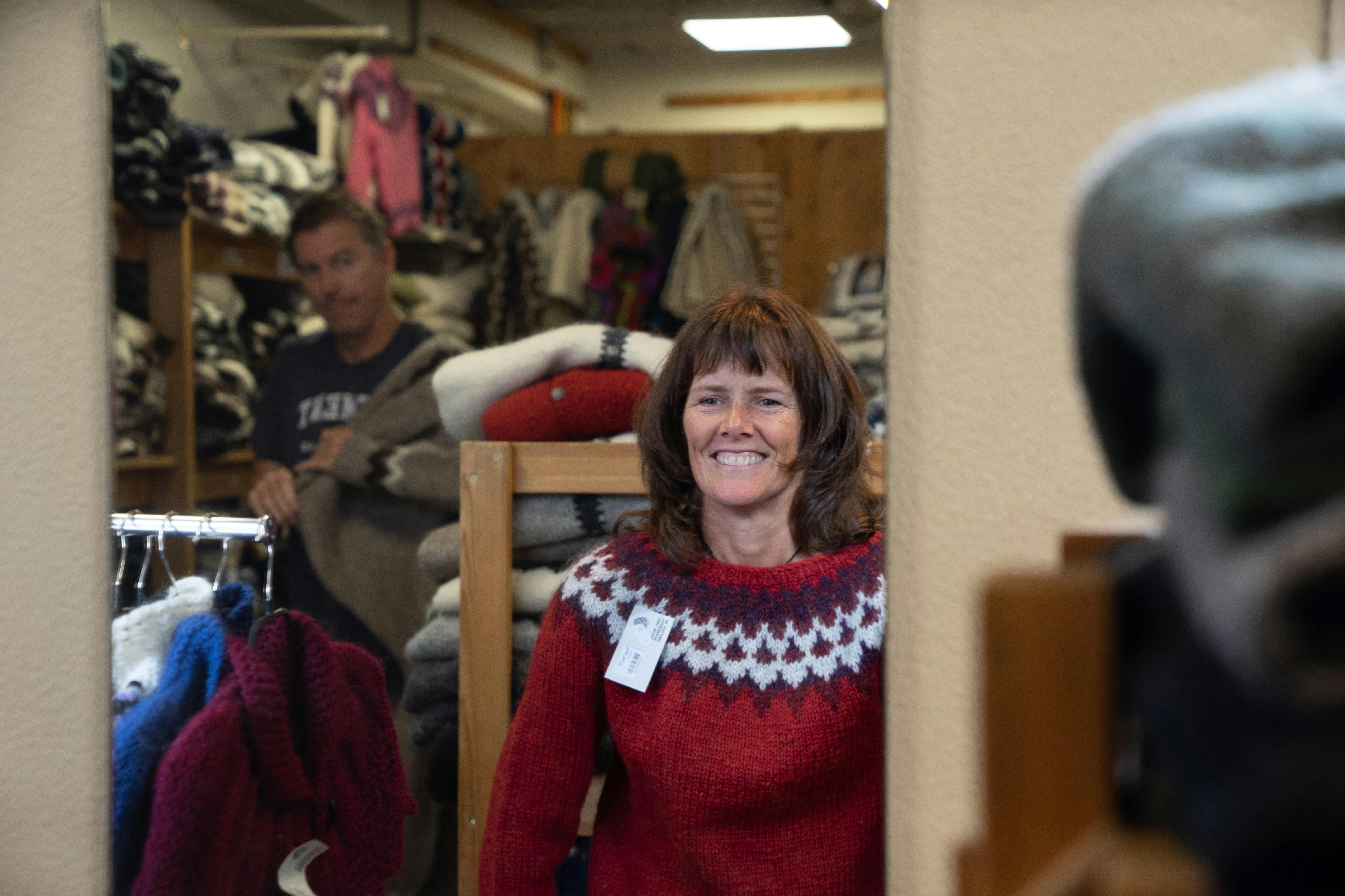 woman trying on a red lopapeysa