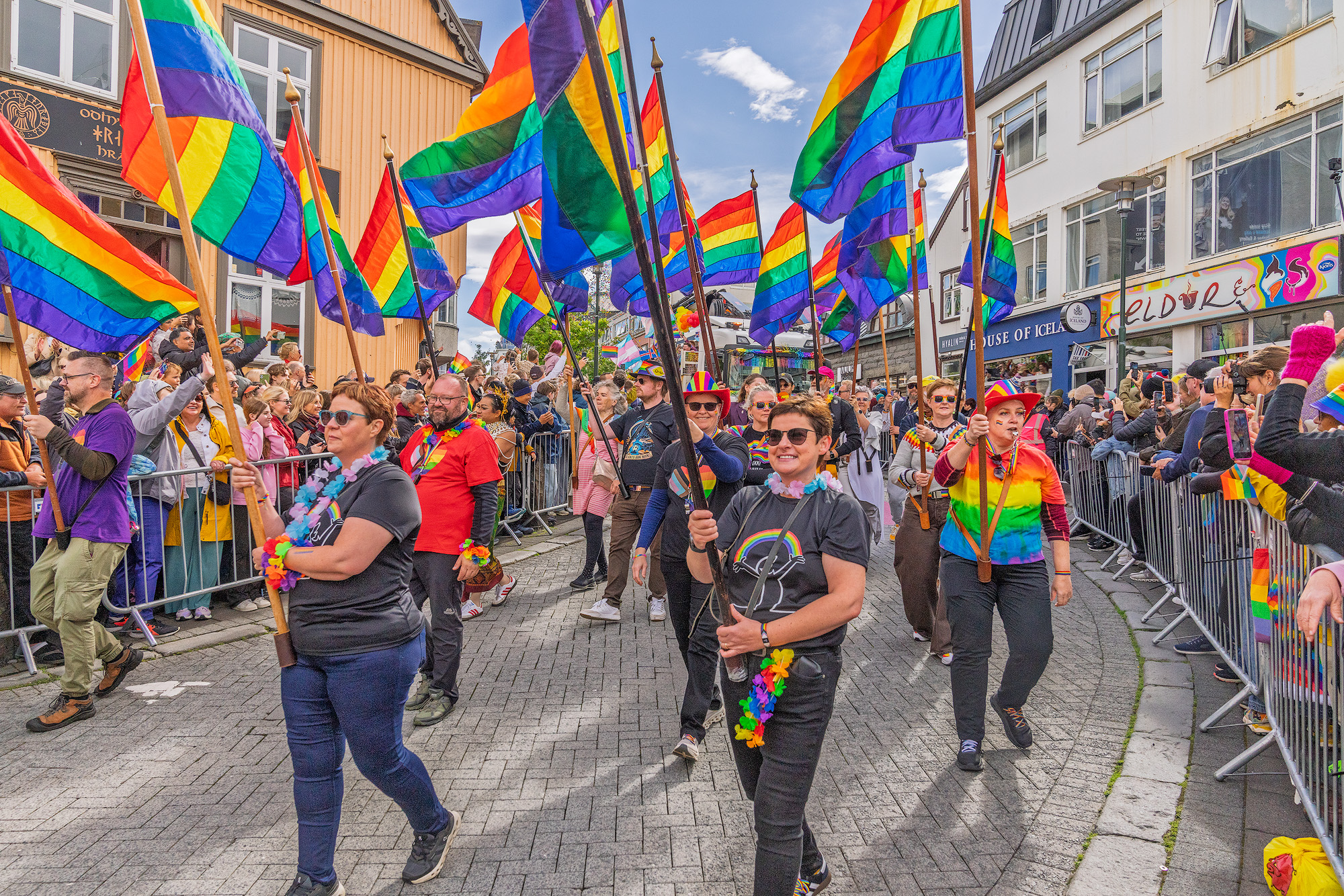 People parading down Laugavegur street in Icealand holding tainbow flags