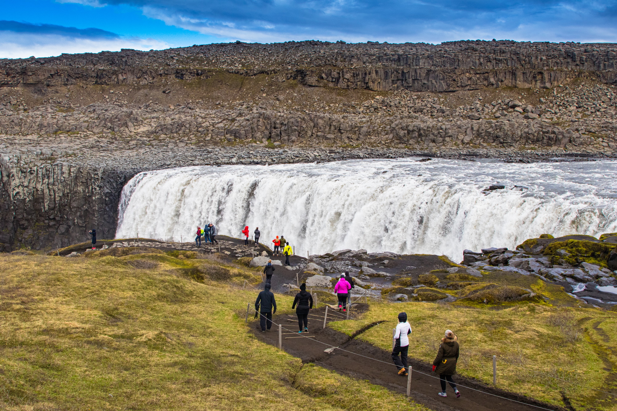 Visitors walking along a trail toward Dettifoss, Europe’s most powerful waterfall, in North Iceland’s Jökulsárgljúfur Canyon.