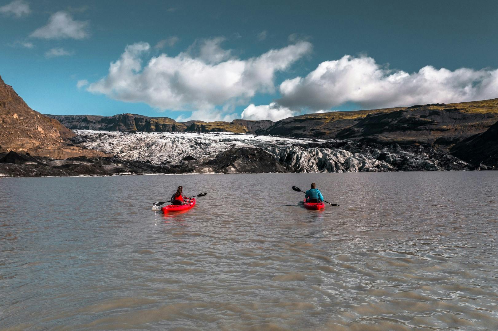 two people kayaking in a glacier lagoon