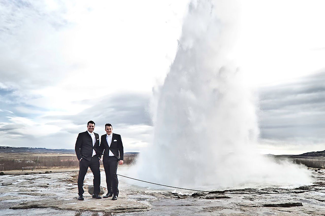 Groom and groom standing in front of Strokkur Geyser