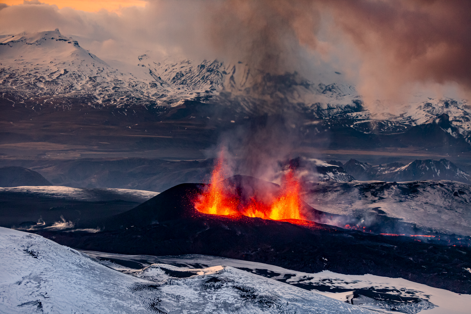 Fire Fountains From Two Erupting Craters, Enveloped By Snowy Mountains