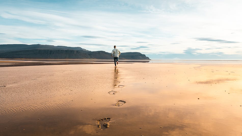 A man running on Raudisandur beach