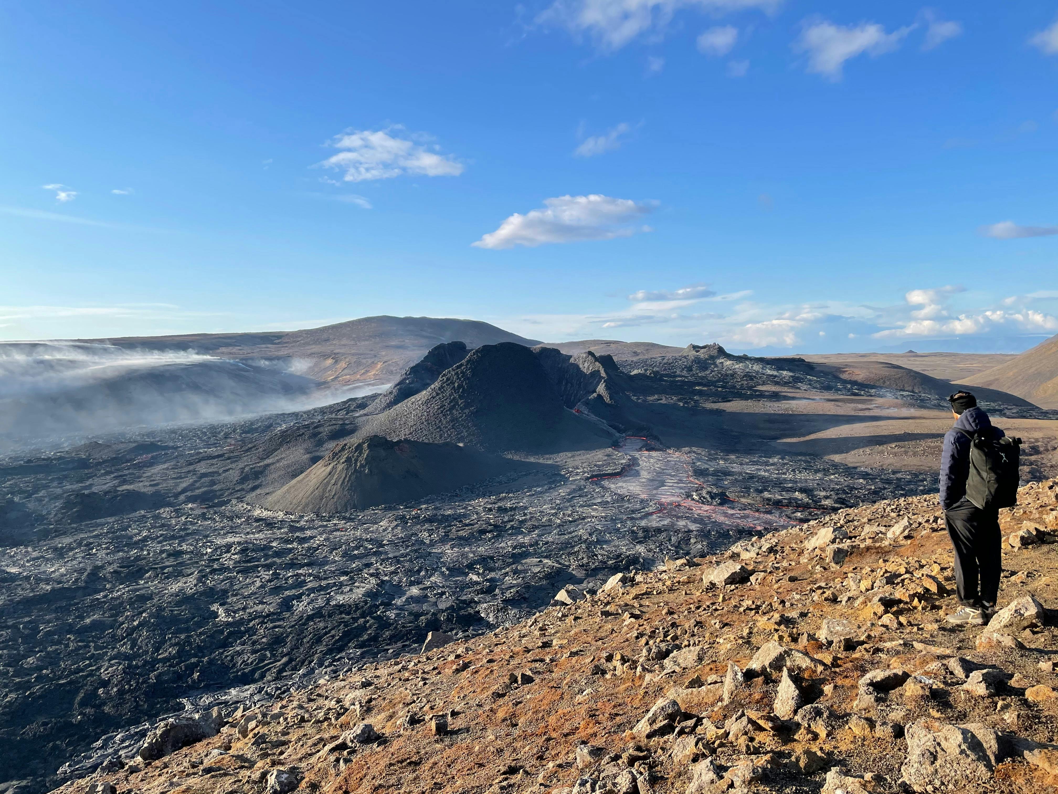 A man admiring the crater and lava river from Fagradalsfjall volcano