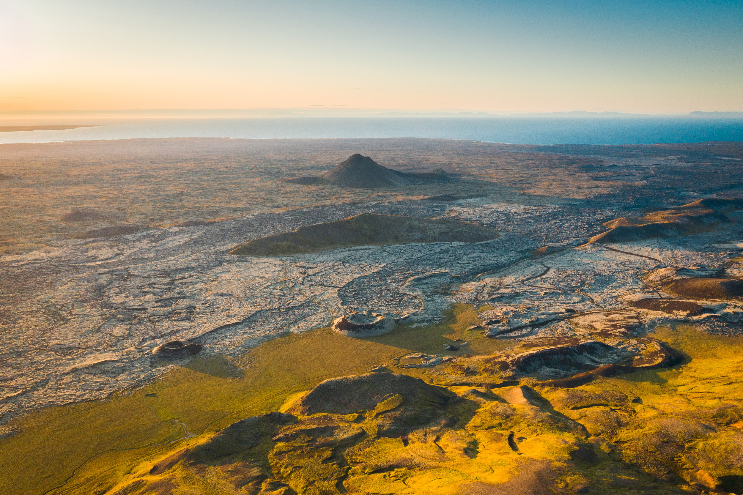 A birds-eye view of a volcanic landscape with lava fields and craters