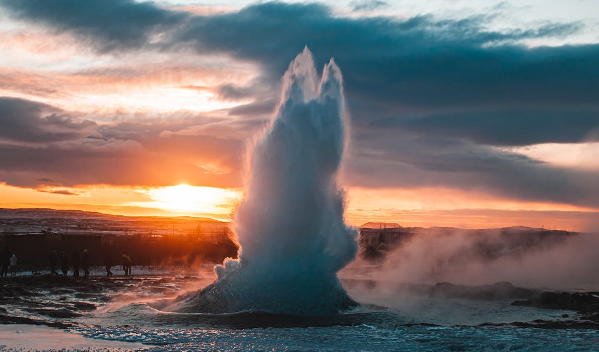 A spouting geyser during sunset