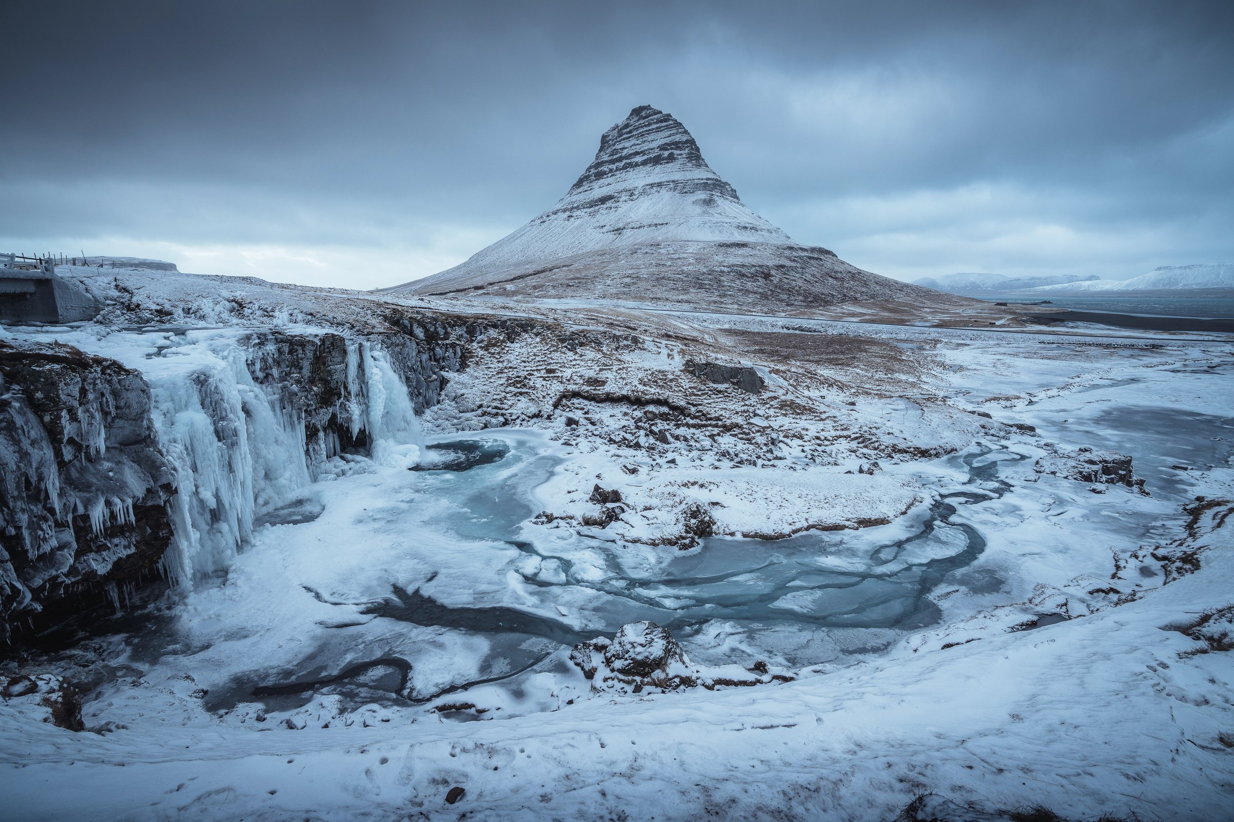 Kirkjufell mountain with the frozen Kirkjufellsfoss waterfall in the front 