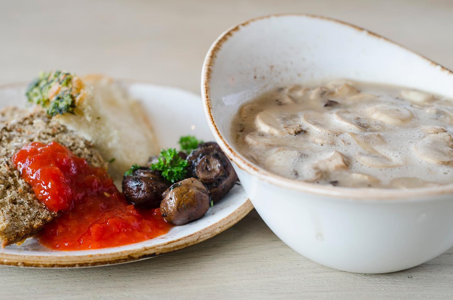 Close-up of mushroom soup with roasted mushrooms and vegetables, made with fresh produce from the Flúðasveppir greenhouse at Farmers Bistro.