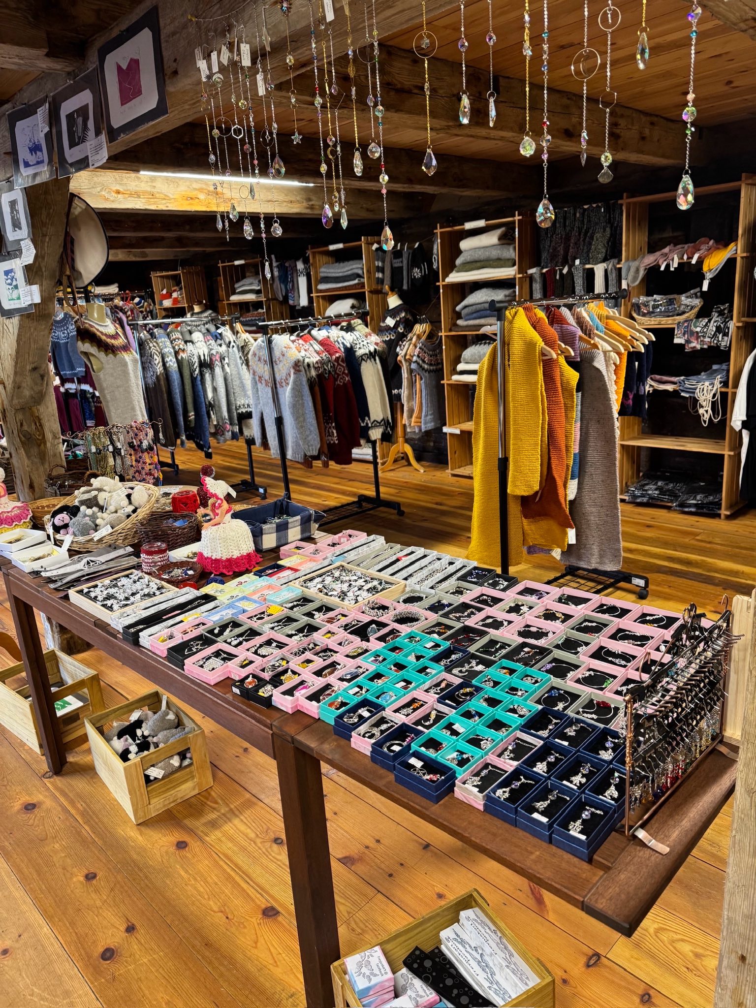 Gallerí Koltra displaying handmade Icelandic crafts, including knitted textiles, small gifts, and locally made decorative items inside a rustic wooden interior.