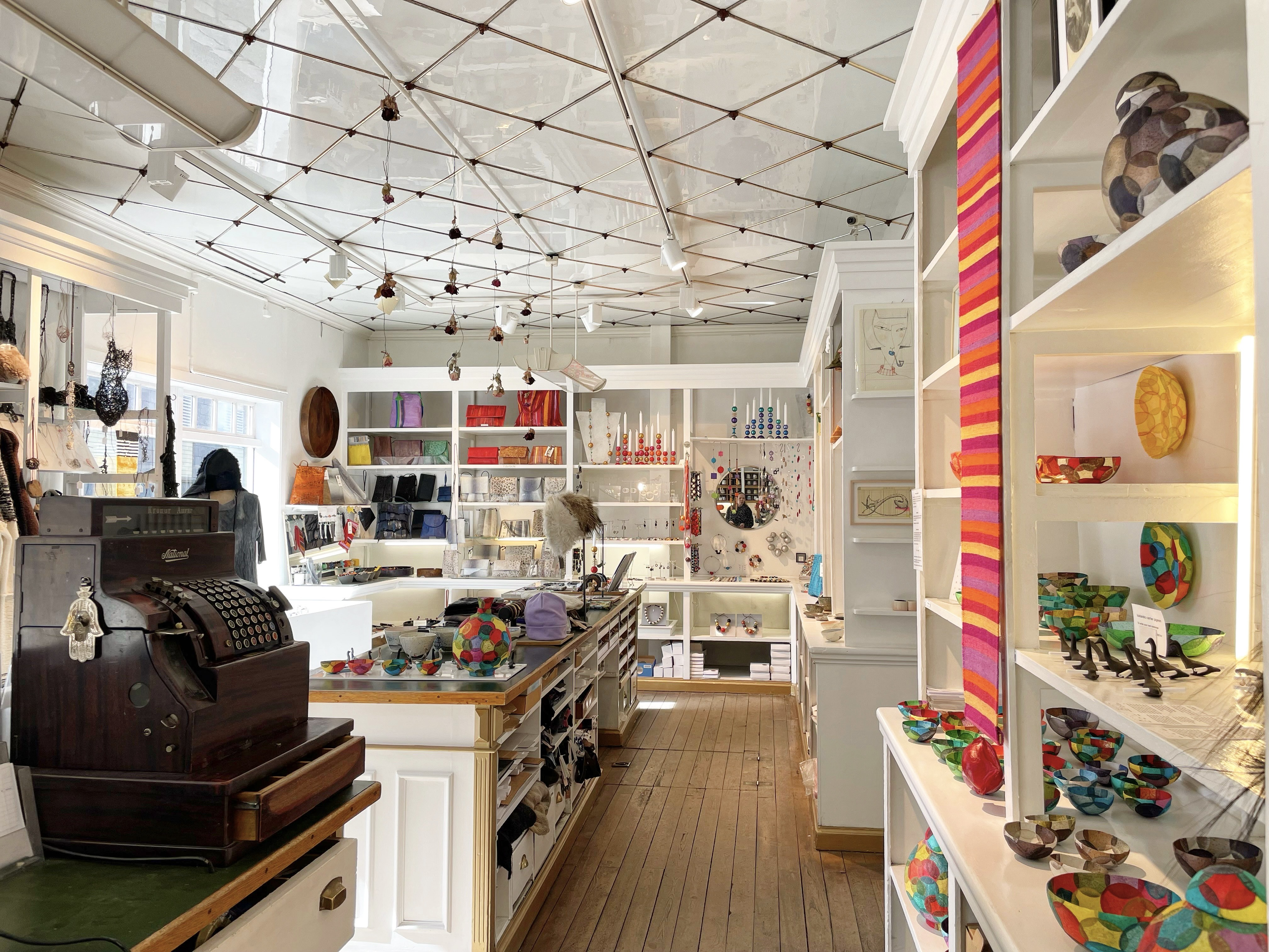 Interior of Kirsuberjatréð design shop in Reykjavík, showcasing Icelandic fashion, jewellery, textiles, ceramics, and handcrafted accessories displayed on shelves and tables.